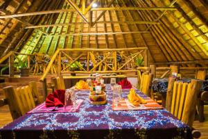 a dining room with a table in a hut at Kibale Forest Camp by NATURE LODGES LTD in Kyenjojo