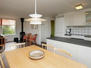 a kitchen and dining room with a table and chairs at 8 person holiday home in Hj rring in Hjørring
