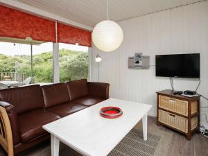 uma sala de estar com um sofá e uma mesa em 8 person holiday home in Hj rring em Hjørring