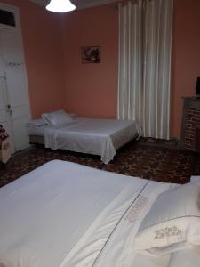 a bedroom with two beds and a window with curtains at Pension Safari in Tangier