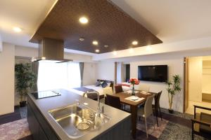 a kitchen and living room with a sink and a living room at Residence Hotel Hakata 19 in Fukuoka