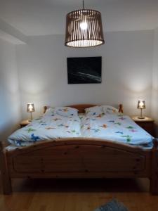 1 cama en un dormitorio con lámpara y 2 mesas en Haus Höber, en Archkogel