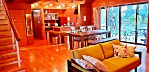ein Wohnzimmer mit einem gelben Sofa und einem Tisch in der Unterkunft Karin Design Cottage in Onna
