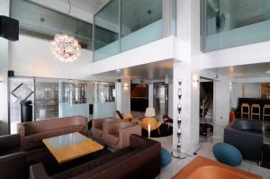 a living room with leather furniture and a chandelier at Maniatis Hotel in Sparta