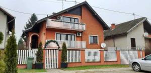 una casa con una valla blanca delante en Rooms Baranjska Oaza, en Bilje