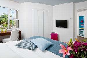 ein Schlafzimmer mit einem Bett mit einem rosa Koffer in der Unterkunft U Coral Beach Club Eilat – Ultra All inclusive in Eilat