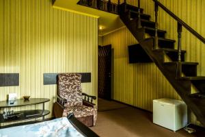 ザポリージャにあるHotel SEMの階段、椅子、テーブルが備わる客室です。