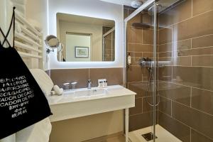 a bathroom with a sink and a shower at Les Villas d'Arromanches, Teritoria in Arromanches-les-Bains