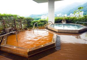 uma banheira de hidromassagem com água castanha em Arima Grand Hotel em Kobe