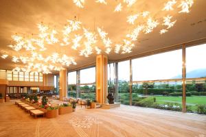 eine große Lobby mit großen Fenstern und einem Kronleuchter in der Unterkunft Arima Grand Hotel in Kōbe