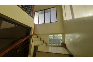 a staircase in a house with a window at Adelaida Pensionne Hotel in Bantayan Island