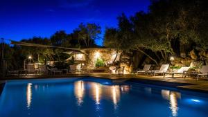 una piscina en un patio trasero por la noche en Hotel A Piattatella, en Monticello