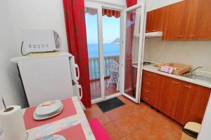 a kitchen with a refrigerator and a view of the ocean at Apartments Filipović in Sobra