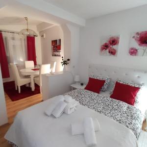 een slaapkamer met een groot wit bed met rode kussens bij Gardos in Belgrado