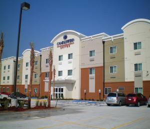 a building with a car parked in a parking lot at Candlewood Suites Avondale-New Orleans by IHG in Avondale
