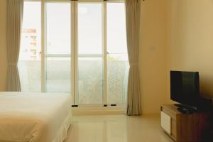 ein Schlafzimmer mit einem Bett und einem Flachbildfernseher in der Unterkunft The Kite in Taitung