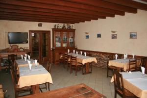 a restaurant with tables and chairs and a tv at Auberge Saint Martin in Saint-Martin-Terressus