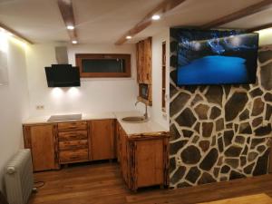 a bathroom with a sink and a tv on a wall at László apartman in Harghita-Băi
