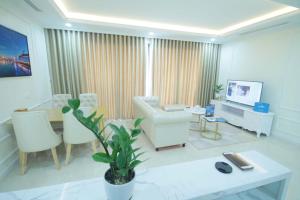 uma sala de estar com um sofá, uma mesa e uma televisão em Vinhomes D'Capitale Apartment - by Bayhomes em Hanói