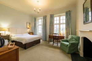 a bedroom with a bed and a desk and a chair at West Dean College in West Dean