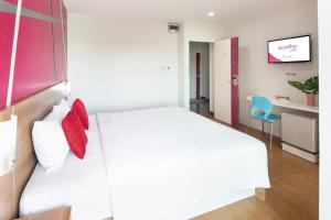 a bedroom with a large white bed with red pillows at Eco Inn Lite Chanthaburi in Chanthaburi