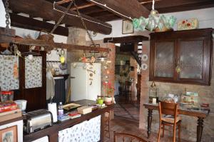 cocina con nevera, mesa y sillas en La Buca, en Castello di Serravalle