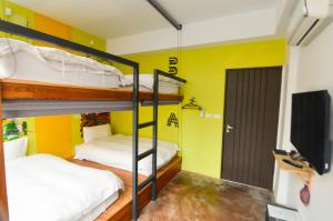 2 łóżka piętrowe w pokoju z żółtymi ścianami w obiekcie Arch Inn w mieście Hualian
