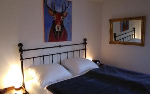 - une chambre avec un lit et une photo de cerf dans l'établissement Ferienwohnung am Rotbach, à Sonthofen