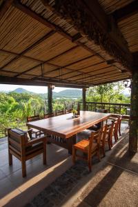 Une grande table et des chaises en bois sont disponibles sur la terrasse. dans l'établissement La Estancia Busuanga, à Busuanga