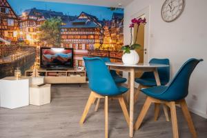 ストラスブールにあるStrasbourg Appart Cosy Hyper Centreのダイニングルーム(テーブル、青い椅子付)