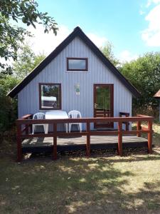 a large wooden bench in front of a house at Grindsted Aktiv Camping & Cottages in Grindsted