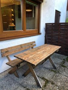 a wooden bench sitting in front of a window at Apartement Zwölferhorn in Sankt Gilgen