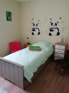 ein Schlafzimmer mit einem Bett mit Panda-Aufklebern an der Wand in der Unterkunft Le Bord d'eau in Montbard