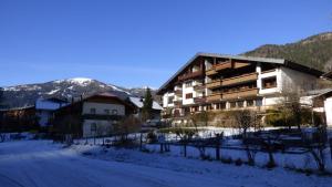 un edificio en la nieve con montañas en el fondo en Appartement Bella Vista, en Bad Kleinkirchheim