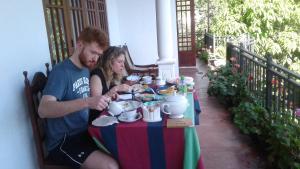 een man en een vrouw aan een tafel met eten bij Sadula Homestay Ella in Ella