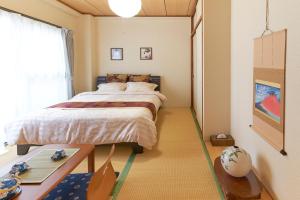 a bedroom with a large bed and a table at ESPERANZA103 広い綺麗快適高速WiFi in Tokyo