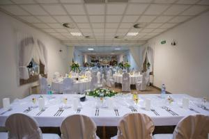 un salón de banquetes con mesas y sillas blancas en Horský hotel Eva, en Svätý Jur