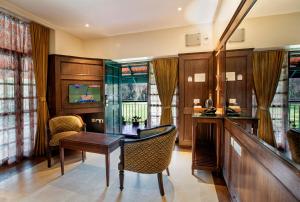 a room with a desk and a table and chairs at Hotel Raindrops in Kodaikānāl