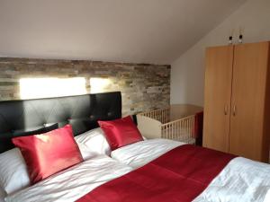 1 dormitorio con 1 cama grande con almohadas rojas en Relax - Ferienhaus in Wien en Viena