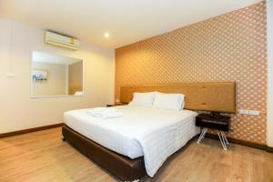 a bedroom with a large bed and a mirror at Parasol Inn Chiang Mai Old City in Chiang Mai