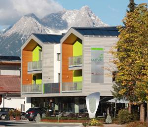 a building with a snow covered mountain in the background at Die Dorfvilla in Maishofen