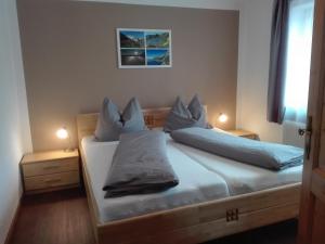 ザンクト・ミヒャエル・イム・ルンガウにあるFerienwohnung Holzerのベッドルーム1室(青いシーツと枕のベッド1台付)