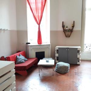 a living room with a red couch and a fireplace at La Maïoun Guesthouse in Nice