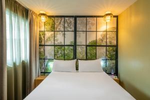 - une chambre avec un lit et une grande fenêtre dans l'établissement ibis Styles Parc des Expositions de Villepinte, à Villepinte