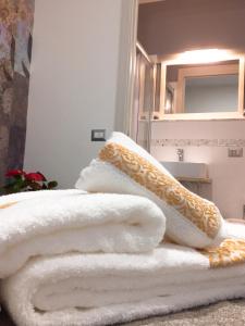 a pile of towels sitting on a bed in a bathroom at Col di Lana in Cagliari