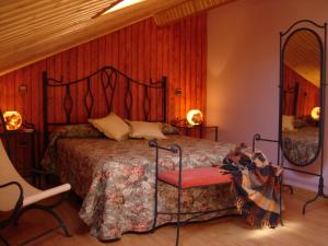 Un dormitorio con una cama, una silla y un espejo. en Hotel Rural El Valle, en Rascafría