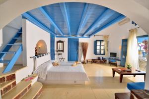 a bedroom with a bed and a blue ceiling at Tamarix Del Mar Suites in Kamari