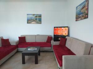a living room with two couches and a tv at Grand Seaview Apartments in Ksamil