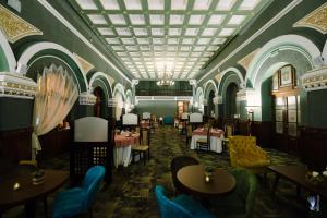 une salle à manger avec des tables et des chaises et un plafond dans l'établissement Hotel La Belle Epoque, à Petroşani