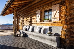 a wooden wall with pillows on a bench on a porch at Luxury Wellness Lusiaski in Bellamonte